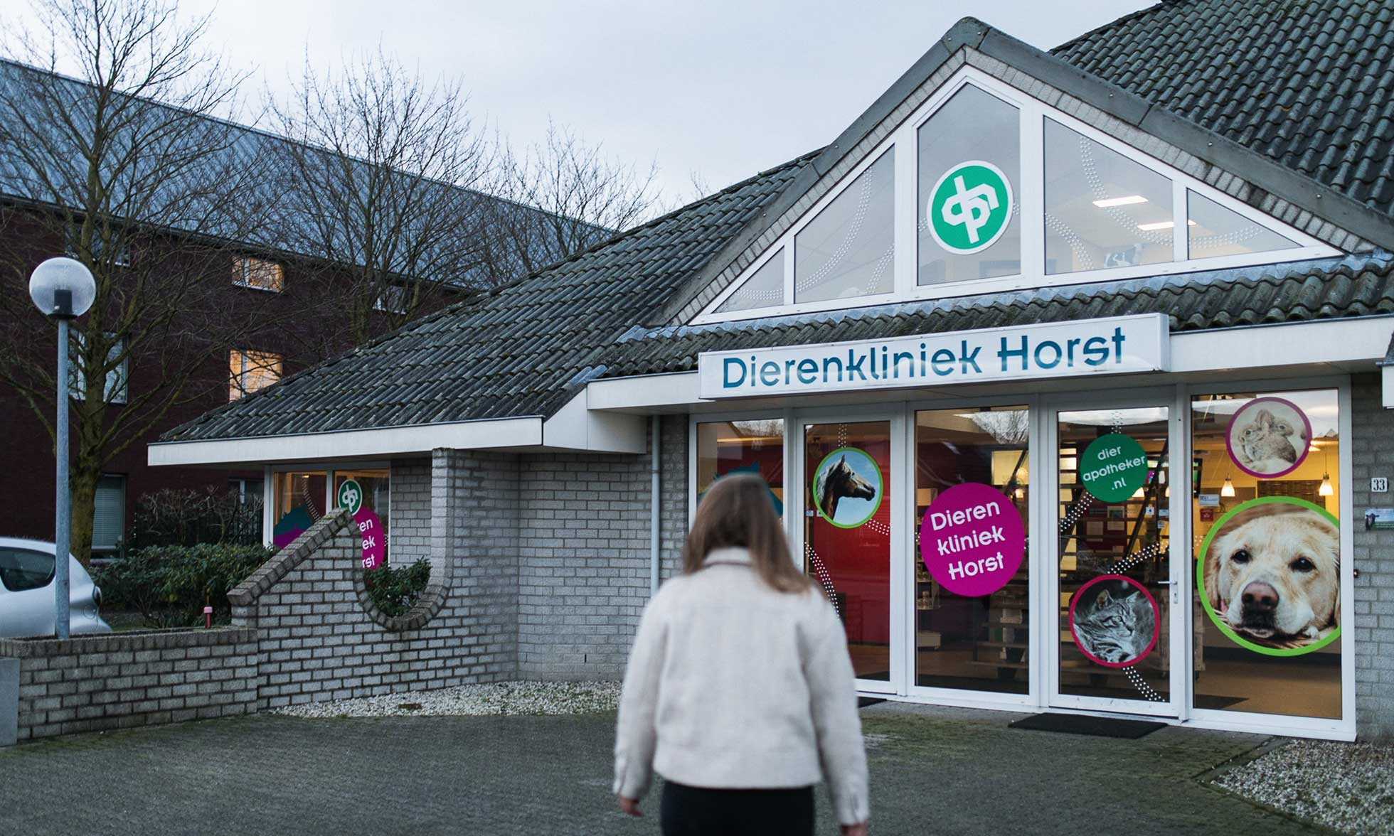 A woman in front of the building of Dierenkliniek Horst