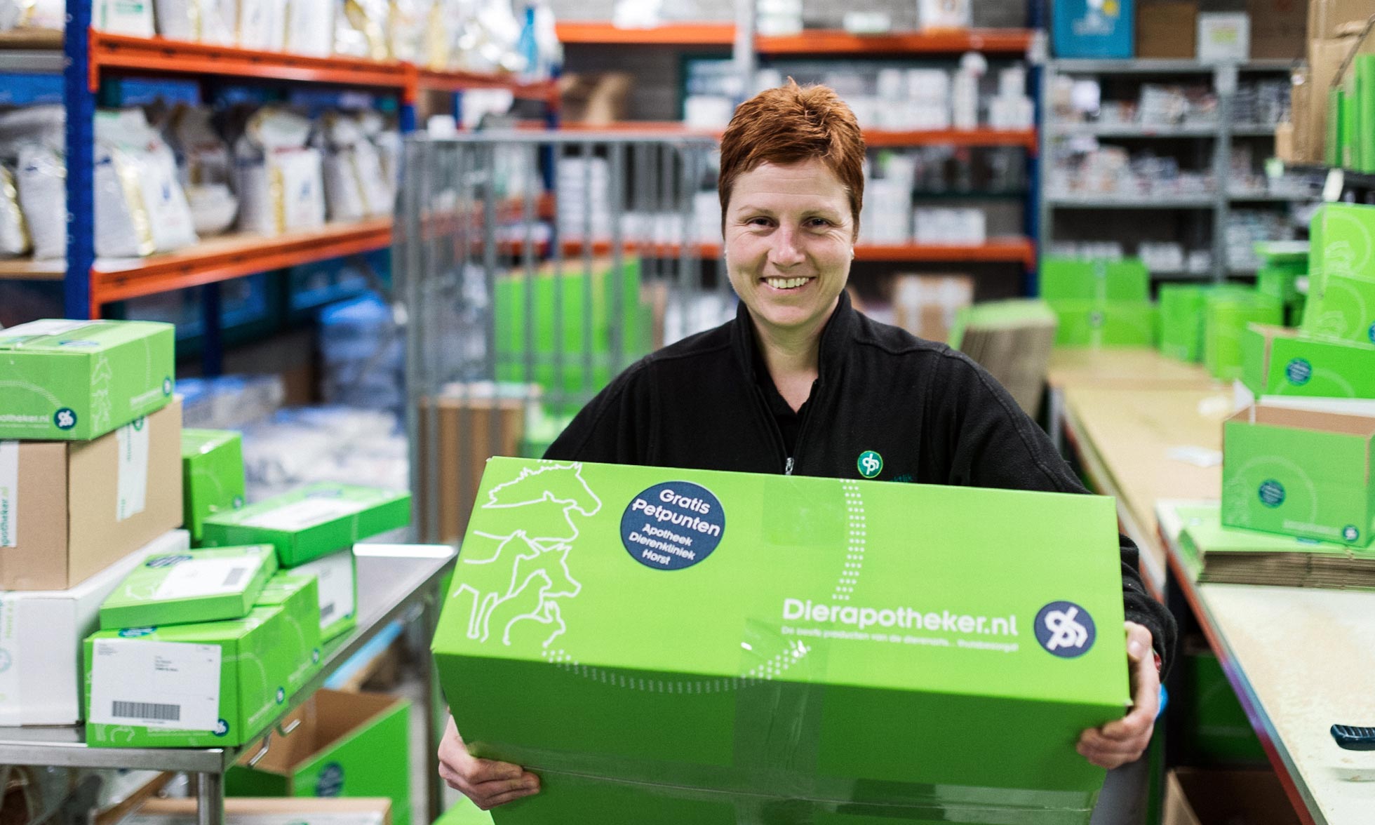 A Dierapotheker employee in the warehouse with a package