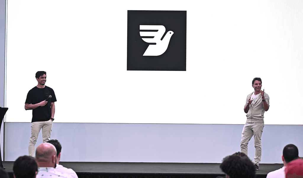 Stage backdrop features the logo of Bird, as Robert stand at the forefront giving a keynote address in Dubai.